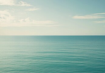 Obraz premium Calm Ocean Water Under Pale Sky with Few Clouds Landscape