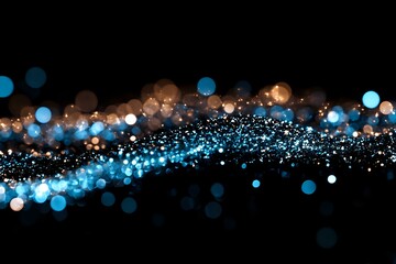Fototapeta premium Abstract glowing blue and golden bokeh lights flowing on black background, creating magical sparkle effect with blurred particles and luminous wave motion.