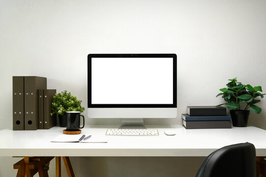 Desktop computer, office supplies, and potted plants on white table