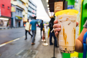 Bubble Tea, or Taro Milk tea, cup on the street in Asia. Bubble Tea is a tea-based drink most often containing chewy tapioca balls
