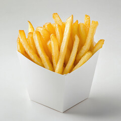 Golden-brown French fries are piled high in a white paper container. The fries are evenly cut and show slight browning on the edges. The container is simple and angular, set against a white background