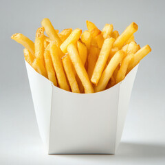 Golden-brown French fries are piled high in a white paper container. The fries are evenly cut and show slight browning on the edges. The container is simple and angular, set against a white background