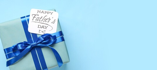 Gift box and paper with text HAPPY FATHER'S DAY on light blue background with space for text, top...