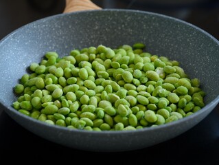 Green Edamame soy beans in a frying pan ready to be cooked