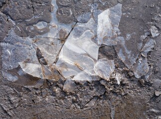 Cracked ice on the dirty ground