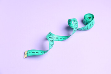 Measuring tape on lilac background