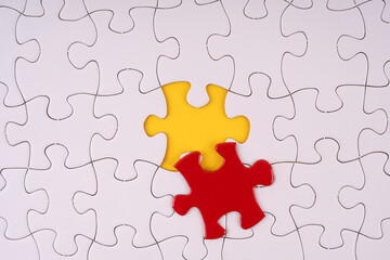 Obraz premium Closeup a set of white jigsaw puzzle and one piece of them is missing and replaced with red piece for concept and idea purpose