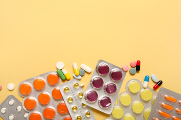Different pills in blister packs on yellow background