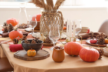 Autumn table setting with pumpkins, pampas grass and pine cones, closeup