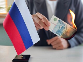 1000 Russian rubles burn like fire in the hand of a businesswoman. Economic monetary inflation in...
