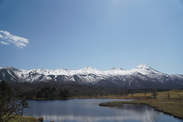 Snow-covered Shiretoko mountains and reflecting lake