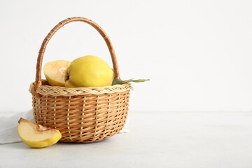 Wicker basket with sweet ripe quinces on white background