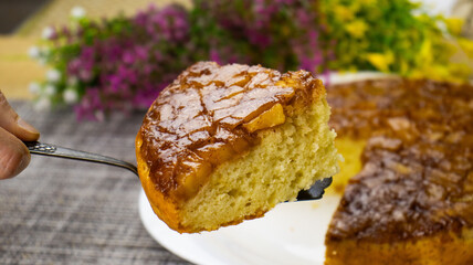 Delightful homemade cake adorned with caramel glaze and surrounded by vibrant flowers during a warm afternoon gathering