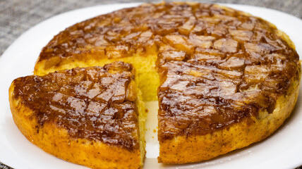 Moist and decadent caramelized cake with a slice taken out, perfect for any dessert lover's gathering or celebration