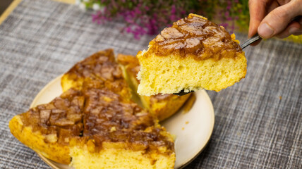 Delicious homemade cake served on a rustic table with vibrant flowers in the background during a sunny afternoon gathering
