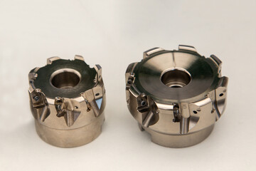 Two different sized end mill bodies without carbide cutting plates.