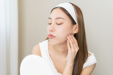 Expression worry asian young woman hand touching pustule around the chin and mouth, allergic when...