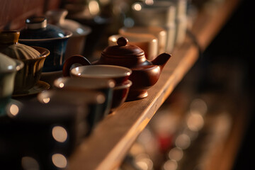 A lot of different dishes for chinese tea drinking. Traditional asian clay teapot at the shelf