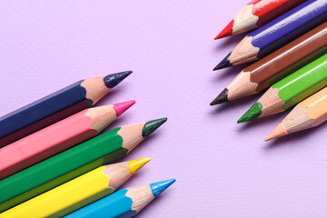 Obraz premium Colorful pencils on purple background, closeup