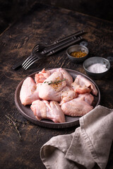 Raw chicken wings on black background.