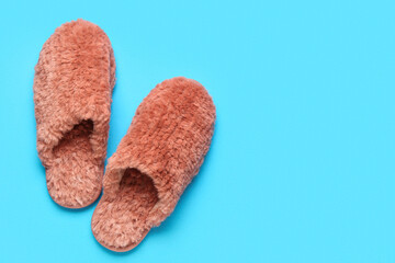 Pair of red soft slippers on blue background. Top view