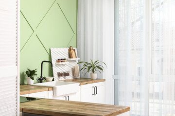 Pegboard, houseplants and sink near window in kitchen