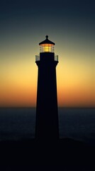 A tall lighthouse stands illuminated against the colorful sunset sky