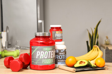 Jars of protein powder with food on table in kitchen