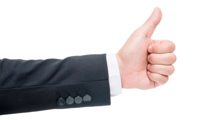 a businessman's hand giving a thumbs up. The hand is wearing a suit and a formal white shirt, it symbolizes approval and agreement