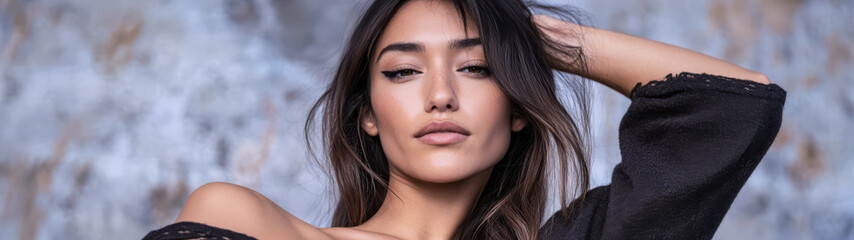 Obraz premium Portrait of a woman with long hair striking a confident pose against a textured background