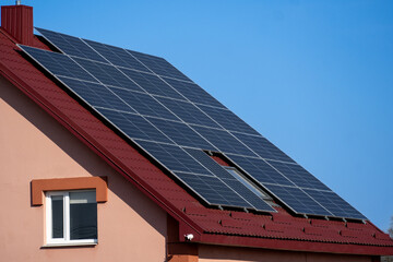 Fototapeta premium Roof with solar panels actively generating solar energy on a sunny day, showcasing advancements in renewable energy technology for homes