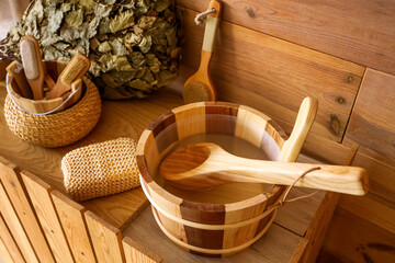 Bucket of water with loofah on counter in sauna, closeup