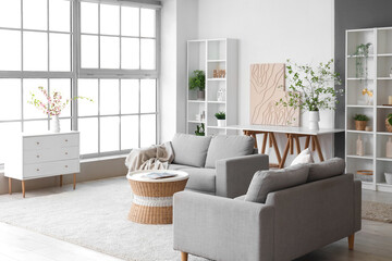 Interior of stylish living room with vase and blooming branches