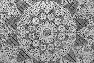 Beautiful white knitted lace on black background. Vintage embroidery pattern.