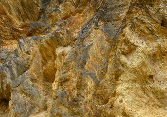 Close-up of a textured rock formation with yellow and gray tones. Natural stone patterns create an abstract background. Perfect for geology, nature, and texture design concepts.