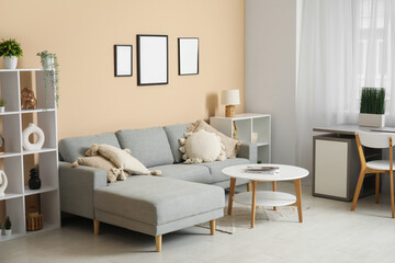 Stylish living room with comfortable sofa, coffee table, workplace and curtains