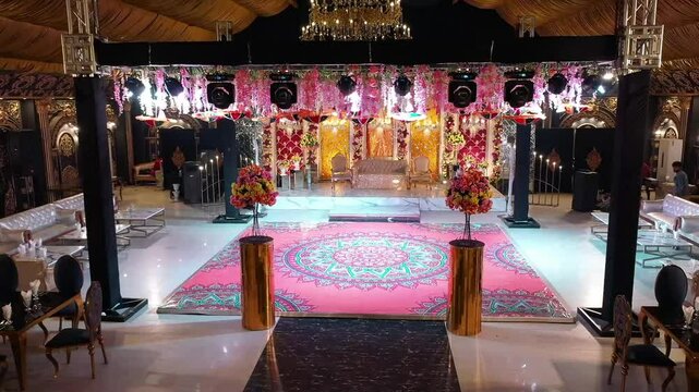 Drone shot of a Mehndi event setup, stage and dance floor in a grand pakistani wedding, Aesthetic wedding stage decoration with beautiful&nbsp;flowers
