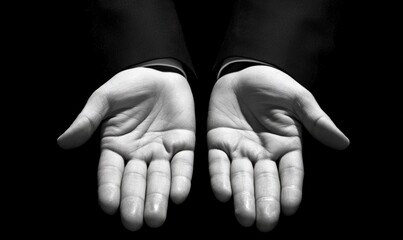 Fototapeta premium Open Hands in Silhouette Against Dark Background Symbolizing Offering, Acceptance, and Generosity in Monochrome Aesthetic for Inspirational Concepts