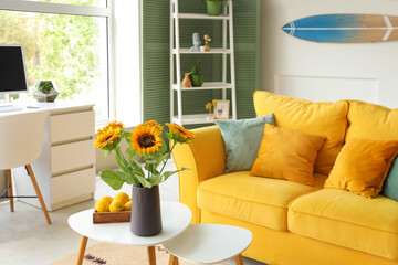 Fototapeta premium Vase with sunflowers and lemons on table in stylish living room
