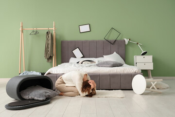 Woman hiding near bed during earthquake in bedroom