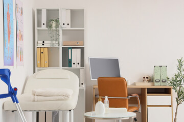Interior of medical office with massage therapist's workplace and couch