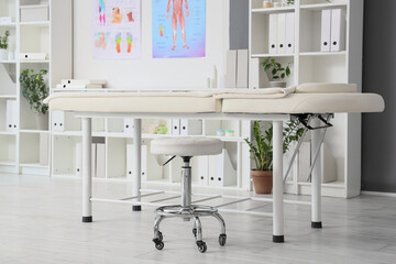 Massage couch with stool in medical office