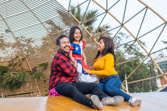 Cheerful chilean family celebrating national holidays, wearing traditional attire and sharing joyful moment together