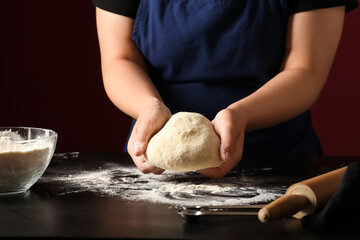 Woman preparing traditional cinnamon rolls in kitchen