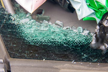 a car window broken and crushed into small pieces on a macro scale.