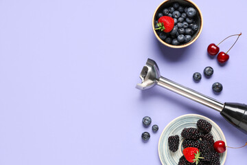 Blender, saucer and bowl with different berries on purple background