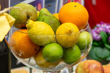 healthy fruits in a clear dish. pears, lemons and oranges on the table in a decorative dish. vitamins and healthy nutrition during breakfast.