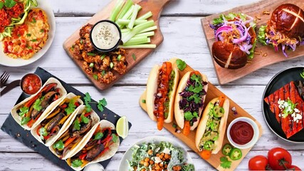 Healthy plant based vegetarian food stop motion table setting. Top view on white wood background. Jackfruit burger, mushroom tacos, watermelon and cauliflower steaks, carrot hot dogs, walnut bolognese - Powered by Adobe