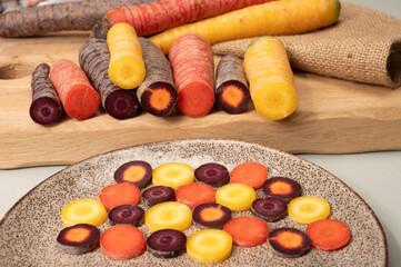 Colorful fresh raw purple, yellow, red and purple-orange carrots roots vegetables from greenhouse in the Netherlands