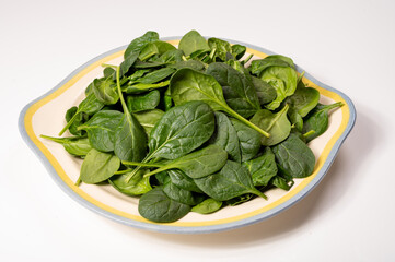 Fresh green baby Spinach leaves, diet and health concept, weight loss, washed spinach on ceramic plate